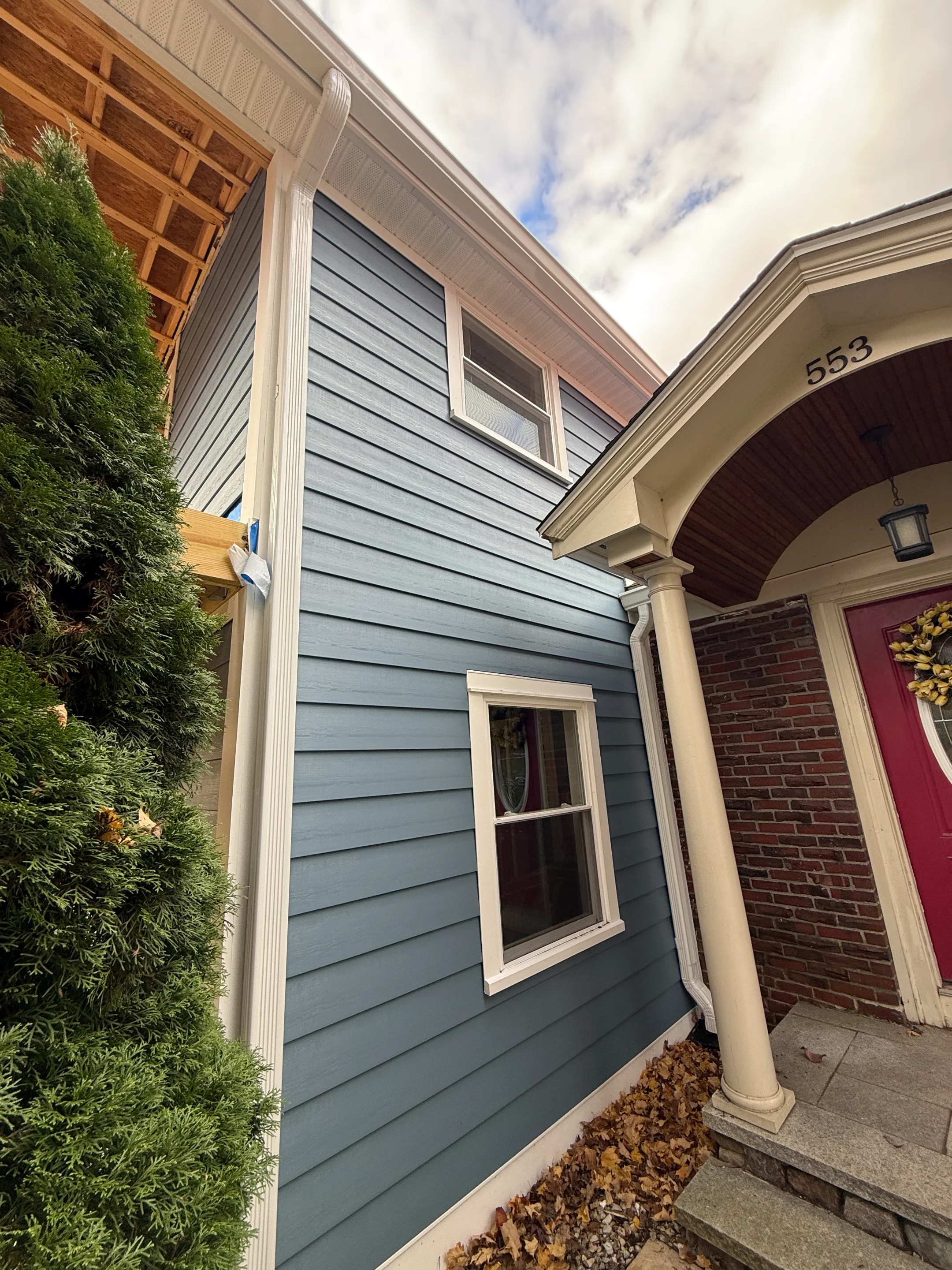 Seamless K-Style gutter installation on a blue-sided home